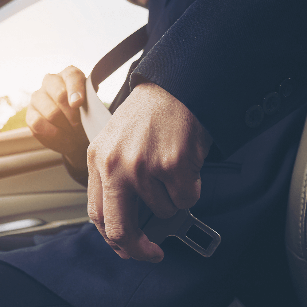 close up of persons hands buckling a seatbelt